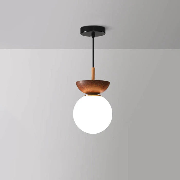Nordisk pendellampa i glas med rund opal kupa och träsockel för hall och vardagsrum