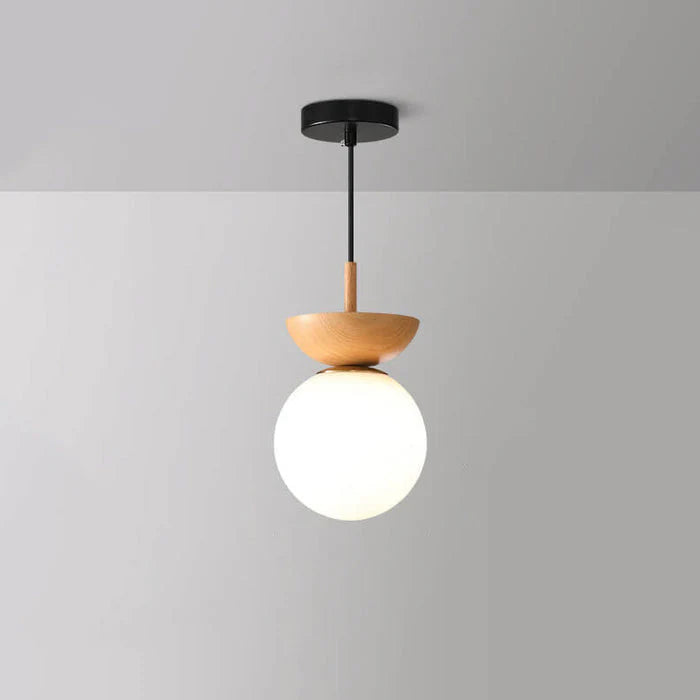 Nordisk pendellampa i glas med rund opal kupa och träsockel för hall och vardagsrum