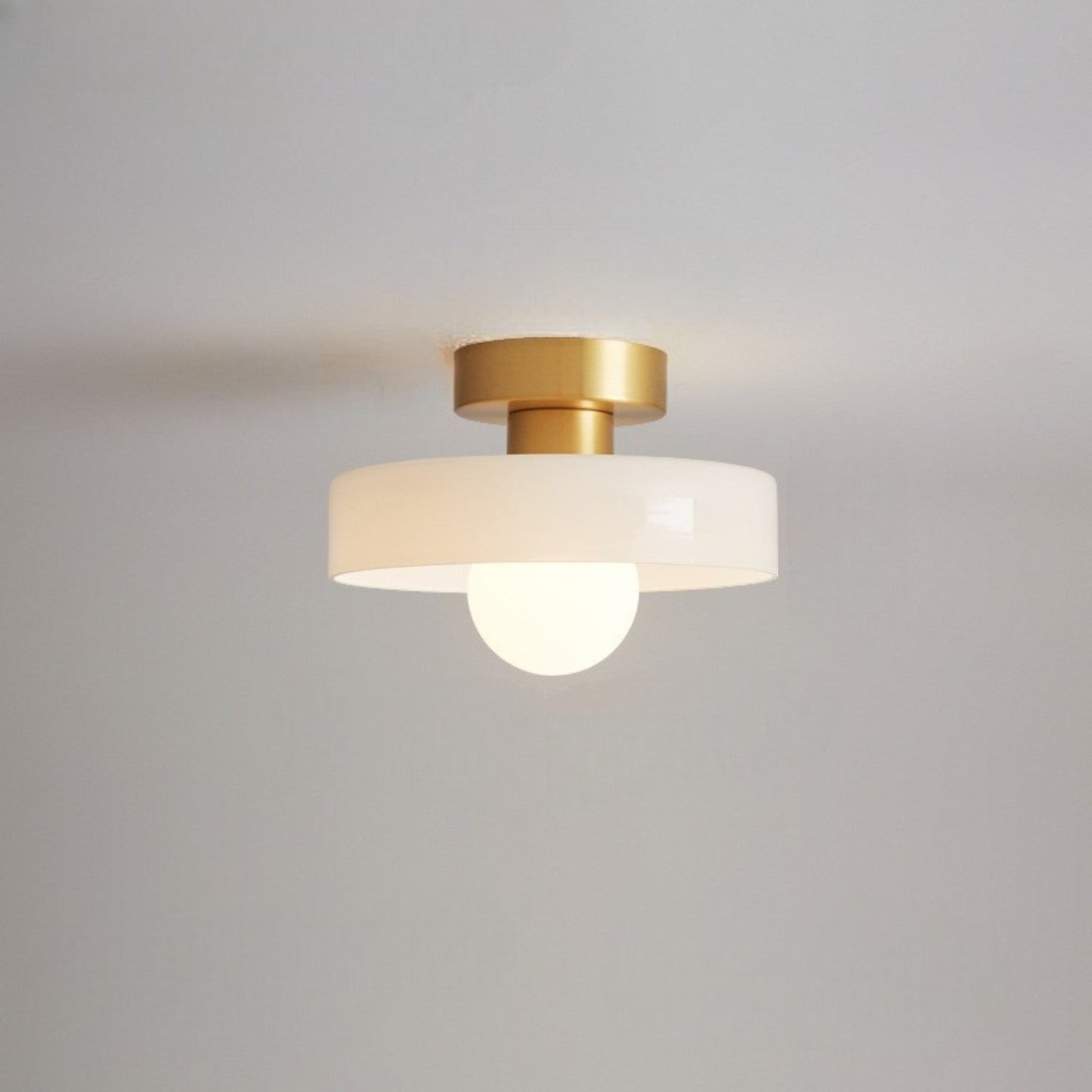 Modern rund taklampa i mässing och glas med geometrisk design