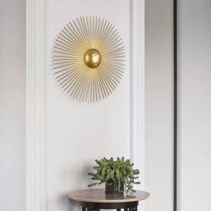 Vägglampa i solformad art déco-design med varm LED-belysning i guldmetall