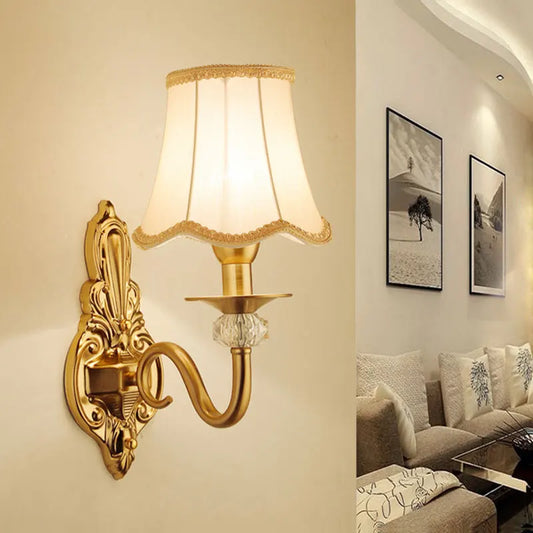 Europeisk vägglampa i guld med tygskärm och klassisk metallbas