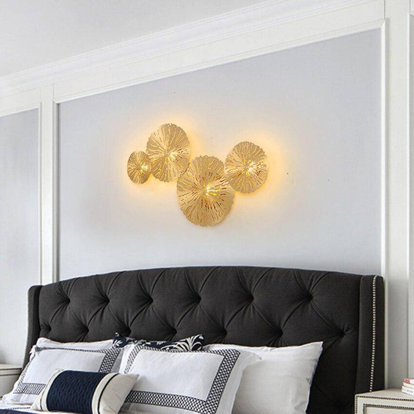 Vägglampa i borstad mässing med blomformad design och LED-belysning