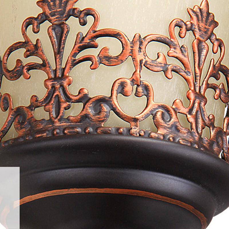 Klassisk vägglampa i brons med frostat glas och dekorativa detaljer