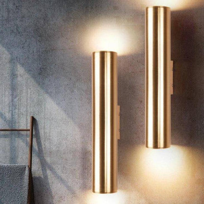 Cylindrisk vägglampa LED i metall med guldig finish och enkel design