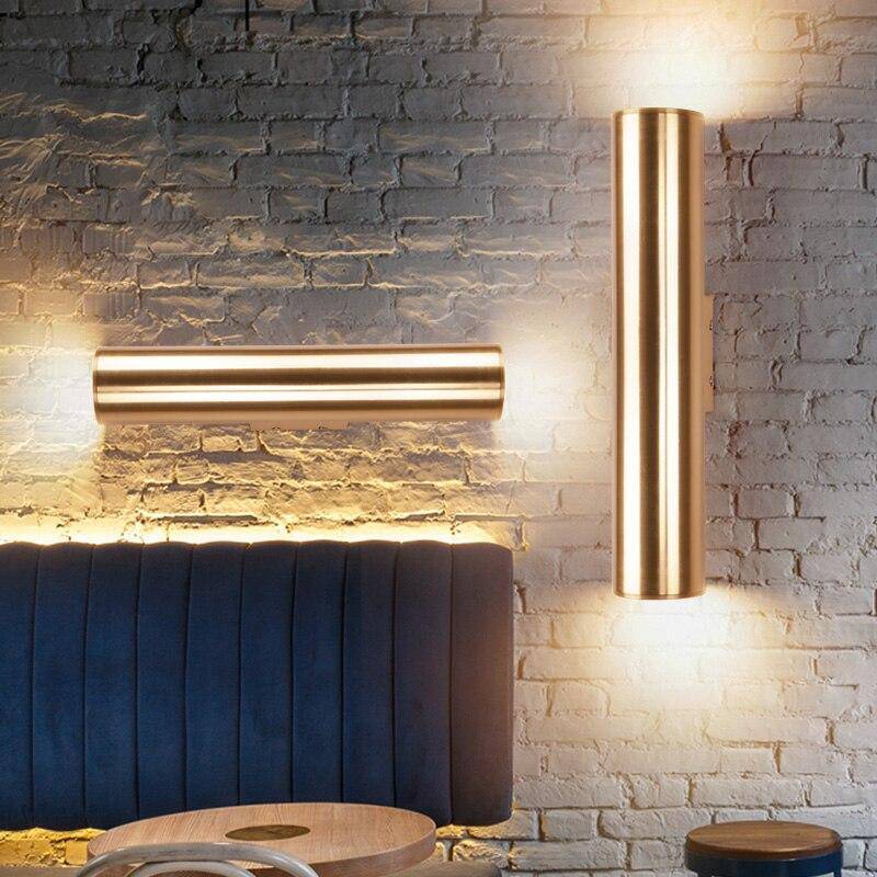 Cylindrisk vägglampa LED i metall med guldig finish och enkel design
